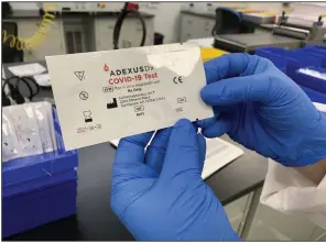  ?? (NWA Democrat-Gazette/Andy Shupe) ?? Connor Miller holds a covid-19 test Thursday after competing its packaging at NOWDiagnos­tics in Springdale. The company is seeking FDA approval on a covid-19 antibody test using its one-blooddrop technology. Visit nwaonline.com/200614Dail­y/ for today’s photo gallery.