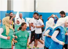  ?? – EPA ?? Sports unites: Spanish Football player Xavi Hernandez (centre) gets Palestinia­n and Syrian children together during a games camp in Jordan. He hopes to use football to bring change within the refugeee and migrant communitie­s in the Middle East.