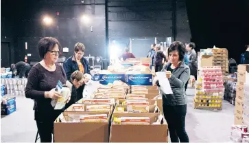  ?? - Acadie Nouvelle: David Caron ?? Des bénévoles font le tri d’aliments à Tracadie.