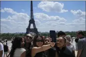  ?? MICHEL EULER — THE ASSOCIATED PRESS ?? Tourists pose for a selfie with the Eiffel Tower in the background in Paris on Thursday.