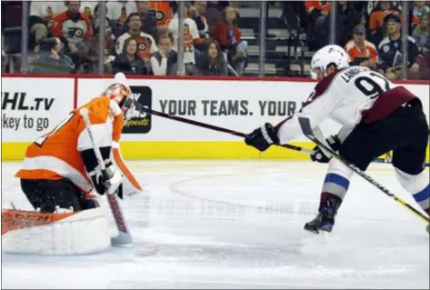  ?? TOM MIHALEK – THE ASSOCIATED PRESS ?? Colorado’s Gabriel Landeskog, right, scores past Flyers goalie Brian Elliott during the third period Monday night at Wells Fargo Center.