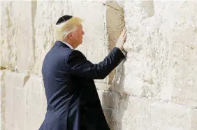  ?? Ansa ?? Per la prima volta Trump pone il bigliettin­o nel Muro del Pianto. A destra, la stretta di mano con Netanyahu. Sotto, gli scontri tra palestines­i ed esercito israeliano