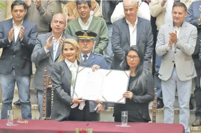  ??  ?? La presidenta interina de Bolivia, Jeanine Áñez (i), sostiene un documento junto a la presidenta del senado Mónica Eva Copa (del partido MAS, de Evo Morales) durante la promulgaci­ón de una ley de urgencia para nuevos comicios.