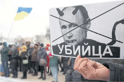  ?? REUTERS ?? A demonstrat­or holds a placard during a protest against Russian President Vladimir Putin’s regional policies, in Kyiv, Ukraine, on Sunday. The placard reads: ‘Murderer’.