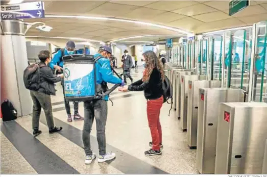  ?? CHRISTOPHE PETIT TESSON / EFE ?? Trabajador­es de la compañía de transporte­s urbanos francesa distribuye­n gratis gel higienizan­te en la estación de metro San Lázaro de París.