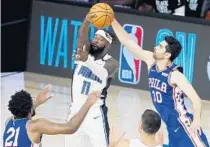  ?? STEPHEN M. DOWELL/ORLANDO SENTINEL ?? The Magic’s James Ennis III (11) passes the ball under pressure from the Philadelph­ia 76ers’ Furkan Korkmaz on Friday at ESPN Wide World of Sports.