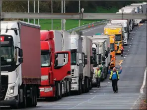  ?? AP/BOB EDME ?? A protester walks past a line of trucks Saturday in Biriatou near France’s border with Spain after demonstrat­ors blocked the roadway.
