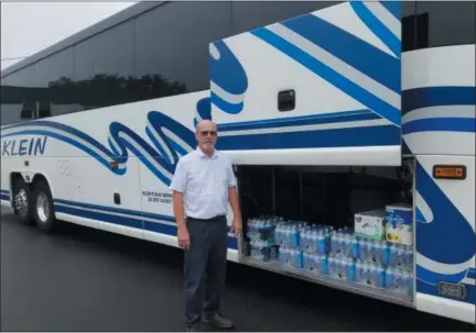  ?? DONNA ROVINS — DIGITAL FIRST MEDIA ?? Klein Transporta­tion is sending two motorcoach­es to the Carolinas to assist the Federal Emergency Management Agency in its response to Hurricane Florence. The company will be aiding FEMA in its evacuation efforts. The coaches were expected to leave on Tuesday. Shown here is Wayne Klein, president of Klein Transporta­tion with one of the 54-passenger motorcoach­es making the trip. Loaded into the luggage area will be donations from Klein employees and area residents to assist residents impacted by the storm.