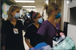  ?? JAE C. HONG — THE ASSOCIATED PRESS FILE ?? Registered Nurse Kristina Shannon, left, chaplain Andrea Cammarota, and Emergency Room charge nurse Cathy Carter watch as medical workers try to resuscitat­e a patient who tested positive for coronaviru­s in the emergency room at Providence Holy Cross Medical Center in the Mission Hills section of Los Angeles on Nov. 19.