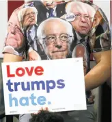  ?? Mike Cardew / Akron Beacon Journal ?? A Bernie Sanders supporter wears a Sanders T-shirt while listening to the Vermont senator campaign for Hillary Clinton at Kent State University in Ohio. Sanders has been trying to rally his young supporters to vote for Clinton.