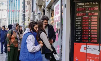  ?? Photograph: Yasin Akgül/AFP/Getty Images ?? The Turkish lira is displayed alongside foreign exchange rates on 21 March in Istanbul.