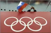  ?? DAVID J. PHILLIP — THE ASSOCIATED PRESS FILE ?? A Russian flag is held above the Olympic Rings at Adler Arena Skating Center during the Winter Olympics in Sochi, Russia in February of 2014. Russia and its ally Belarus have been invited to compete at the Asian Games in the next step to qualify athletes for next year’s Paris Olympics. One year after the invasion of Ukraine began, Russia’s reintegrat­ion into the world of sports threatens to create the biggest rift in the Olympic movement since the Cold War.