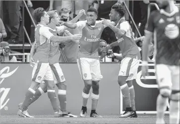 ?? Thearon W. Henderson Getty Images ?? ARSENAL’S CHUBA AKPOM, right, celebrates with teammates after scoring against the MLS All-Stars.