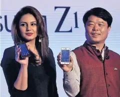  ?? REUTERS ?? Hyun Chil Hong, right, president and CEO of Samsung India Electronic­s, and Bollywood actress Huma Qureshi hold the new Z1 smartphone­s at its launch in New Delhi yesterday.