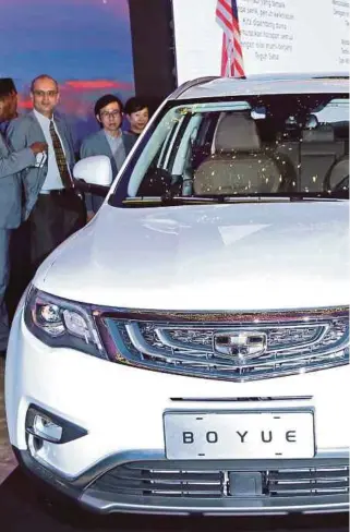  ?? PIC BY
ASYRAF HAMZAH ?? Prime Minister Datuk Seri Najib Razak with the new Geely Boyue after the signing of the agreement between DRB-Hicom Bhd and Zhejiang Geely Holdings Group in Kuala Lumpur yesterday. With him is Zhejiang Geely chairman Li Shufu (fifth from right).