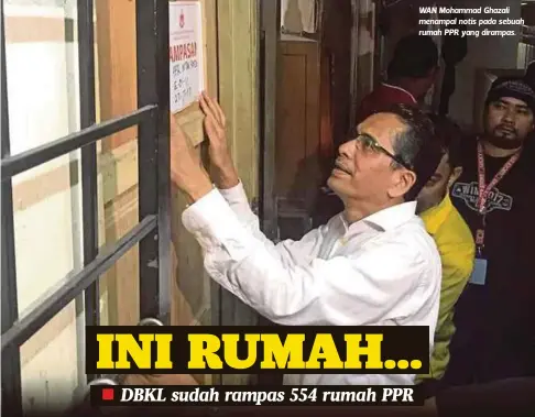  ??  ?? WAN Mohammad Ghazali menampal notis pada sebuah rumah PPR yang dirampas.