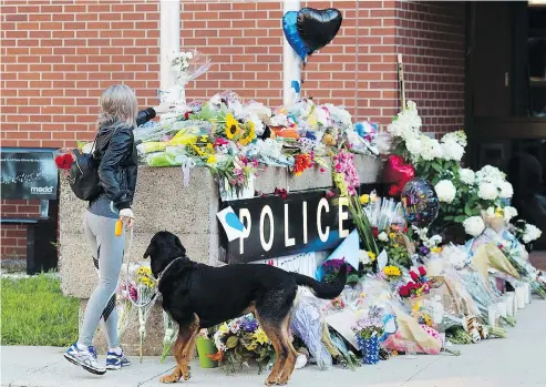  ?? ANDREW VAUGHAN / THE CANADIAN PRESS ?? Flowers are placed on a makeshift memorial outside the police station in Fredericto­n on Saturday. Two city police officers were among four people who died in a shooting in a residentia­l area Friday. Matthew Vincent Raymond has been charged with four counts of first-degree murder.