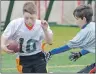  ?? JASON SIMMONDS/JOURNAL PIONEER ?? Blake Blackett of the Charlottet­own Privateers attempts to grab the flag of the Summerside White Spartans’ Rodney Robinson during under-13 play at the second annual Domino’s Spartans Bowl flag football tournament Sunday in Summerside.