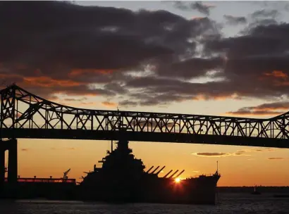  ?? BOStON HEraLD FILE ?? SPANNING HISTORY: The sun sets behind the oft-repaired Braga Bridge and the USS Constituti­on in Fall River.