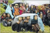  ?? WALLY SANTANA/ ASSOCIATED PRESS ?? Villagers wait in the rain as an aid relief helicopter lands Wednesday at their remote mountain village of Gumda, near the epicenter of Saturday's temblor in the Gorkha District of Nepal.