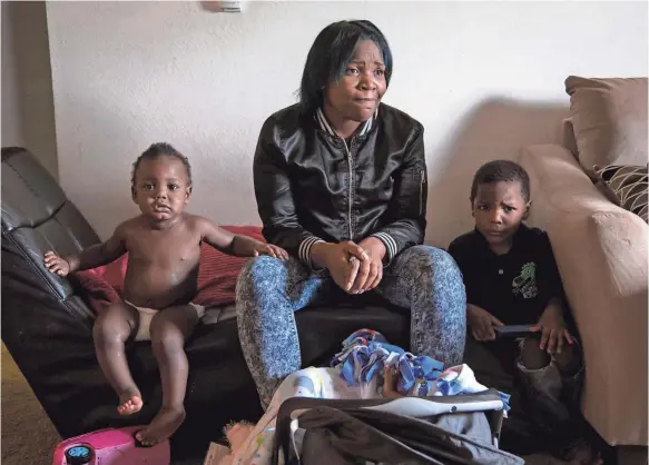  ?? RYAN GARZA DETROIT FREE PRESS, VIA AP ?? Ariana Hawk, 27, along with her sons Aiden, left, and Sincere, moved from Flint, Mich., to nearby Swartz Creek. She’s now ineligible for extra food aid for Flint residents.