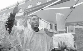  ?? ALGERINA PERNA/BALTIMORE SUN ?? Cory Clark has the perfect product for another rainy day - ponchos for $5 that he was selling outside his grandmothe­r’s home on Winner Avenue.