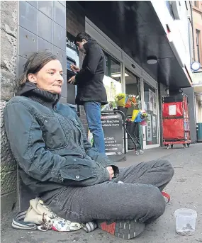 ??  ?? Beggar Lisa Rigden sitting near an ATM on Dundee’s Perth Road.