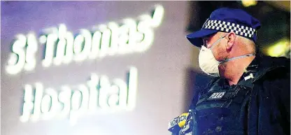  ?? AP ?? A police officer stands outside St Thomas’ Hospital in central London as British Prime Minister Boris Johnson was moved to intensive care after his coronaviru­s symptoms worsened on Monday.