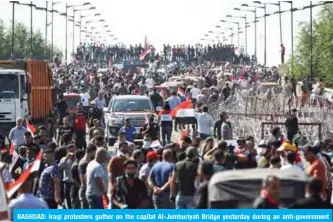 ??  ?? BAGHDAD: Iraqi protesters gather on the capital Al-Jumhuriyah Bridge yesterday during an anti-government protest. — AFP