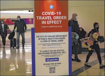  ?? Charles Rex Arbogast The Associated Press ?? Travelers arriving Nov. 24 at Midway Airport in Chicago are reminded of the city’s COVID-19 travel orders. Data shows millions traveled to gather on Thanksgivi­ng.