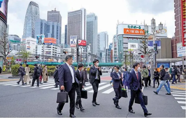  ?? Reuters ?? ↑
Passersby walk on the street at Shinjuku district in Tokyo, Japan on Thursday.