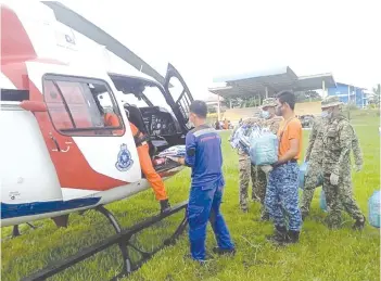  ??  ?? The police helicopter with food assistance landed at SK Liu, SK Malubang, SMK Telaga and SK Maringgan by air.