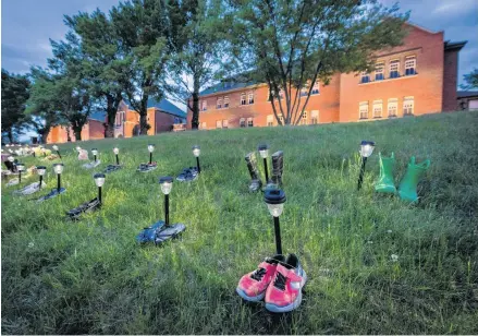  ?? REUTERS ?? Pairs of children's shoes and toys are seen at memorial in front of the former Kamloops Indian Residentia­l School after the remains of 215 children, some as young as three years old, were found at the site, in Kamloops, B.C.