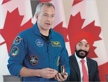  ?? ADRIAN WYLD THE CANADIAN PRESS ?? Science Minister Navdeep Singh Bains looks on as David Saint-Jacques speaks with students during an event Wednesday in Ottawa.