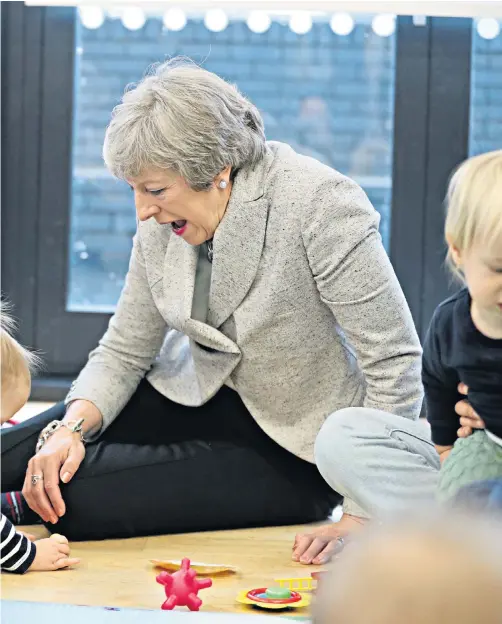  ??  ?? Prime Minister Theresa May took a break from Brexit yesterday by joining a parent and baby group during a visit to the Kentish Town health centre in north London