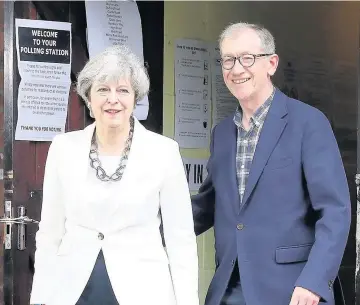  ??  ?? > Conservati­ve Party leader Theresa May and husband Philip arrive cast their votes in Maidenhead, Berkshire