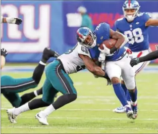  ?? JOHN BLAINE — FOR THE TRENTONIAN ?? Giants running back Wayne Gallman (22) is hit by Eagles linebacker Nigel Bradham (53) as he runs for a first down during Sunday’s game at MetLife Stadium. The Eagles’ defense has struggled to make tackles during the last three weeks.