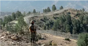  ?? Reuters ?? A soldier stands guard along the border fence at the Angoor Adda outpost on the border with Afghanista­n in South Waziristan. —