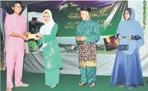  ??  ?? TAHNIAH: Fatimah (dua kiri) menyampaik­an insentif kepada pelajar cemerlang pada Majlis RamahTamah Aidilfitri Taman Desa Guru di Kuching malam kelmarin. Turut kelihatan Yusuf (dua kanan).