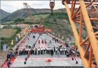  ?? XU GUO / FOR CHINA DAILY ?? China Tiesiju Civil Engineerin­g Group employees complete the closure of the Yuanjiang Super Railway Bridge in Yunnan province on Wednesday.