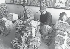  ??  ?? Abdelwahd Hafid, Mohamed Mohsime and Itri El Bermossi craft tiles in the workshop El Bermossi manages in Fez, Morocco. SOPHIE POLLOCK