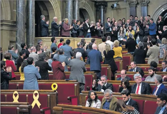  ?? / ARBERT GARCIA ?? Diputados separatist­as, de espaldas, aplauden a los familiares de Jordi Turull. Los constituci­onalistas permanecen sentados.