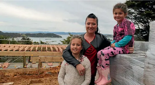  ??  ?? Rena Belcher with her daughters Lily, 8, and Charlotte, 5, check out progress on their new home being built at Parua Bay.