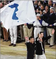  ?? CHANG W. LEE / THE NEW YORK TIMES ?? Pak Jang Choo of North Korea and Chung Eun-Soon of South Korea march with a unified emblem of the two Koreas during the opening ceremony of 2000 Summer Olympics in Sydney, Australia.