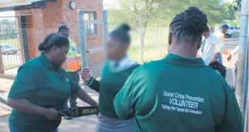  ?? Orrin Singh ?? A female pupil is scanned for any dangerous weapons by Social Crime Prevention volunteers at the Old Mill High School main gate on Tuesday morning