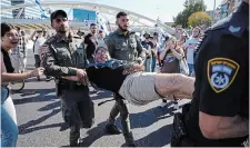  ?? ARIEL SCHALIT THE ASSOCIATED PRESS ?? Israeli police officers disperse demonstrat­ors blocking a highway at a protest against plans by Prime Minister Benjamin Netanyahu’s government to overhaul the judicial system, in Tel Aviv on Thursday.