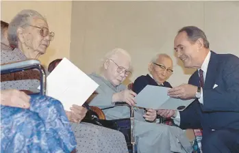  ?? DENNIS COOK/AP 1990 ?? Attorney General Dick Thornburgh presents $20,000 checks through the Civil Liberties Act of 1988 to Kisa Isari, left, Hau Dariki and Mamoru Eto. The three were among many Japanese Americans imprisoned in the U.S. during WWII.