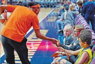  ?? SEAN D. ELLIOT/THE DAY ?? Connecticu­t Sun guard Jasmine Thomas greets a group of young fans watching the team warm up before facing the Phoenix Mercury in WNBA action Friday at Mohegan Sun Arena.