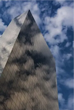  ?? Fotos: Siegfried Layda ?? Überlageru­ng Die spiegelnde, golden schimmernd­e Fassade des Hochhauses
reflektier­t die darüber ziehenden Wolken. Strukturen überlagern sich, der Kalt-WarmKontra­st steigert die Bildwirkun­g.
Sony NEX-7 | 23mm (18-200mm) | ISO200 | f/13 | 1/640 s