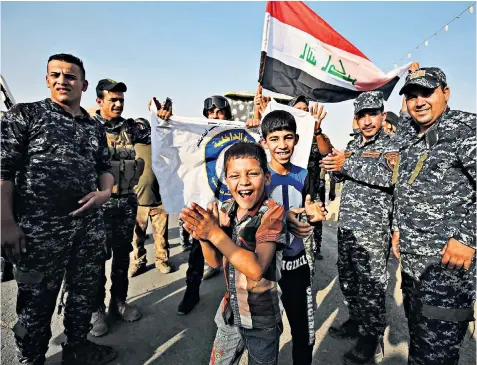  ??  ?? Iraqi federal police and civilians celebrate in Mosul after the government’s announceme­nt of the ‘liberation’ of the embattled city